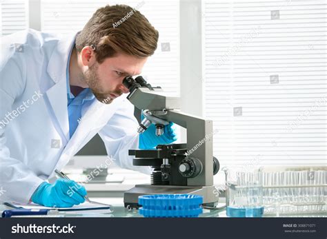 Person Looking Through Microscope