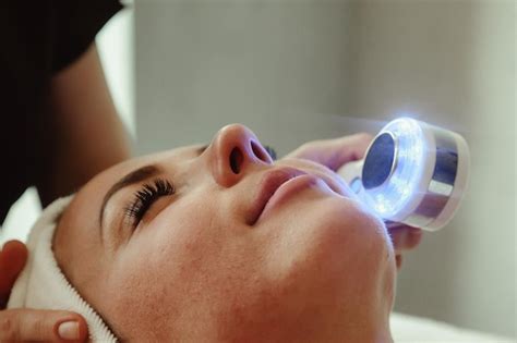 Beautician doing led light therapy to woman with problematic skin in ...