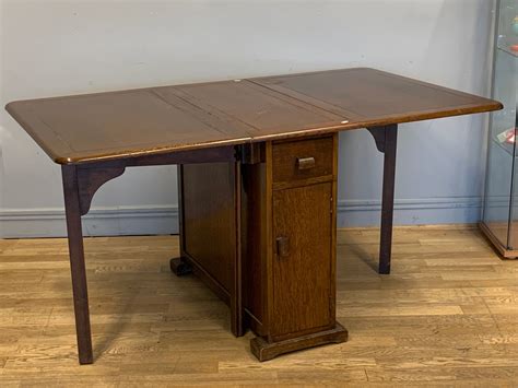 A dropleaf dining table, storage under at either side with a single ...