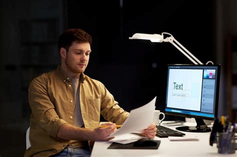 Designer with papers working at night office | Premium Photo