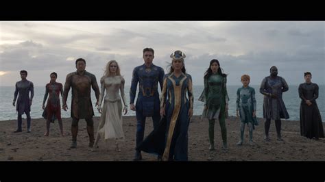 Download Eternals Members In Beach Shore Wallpaper | Wallpapers.com