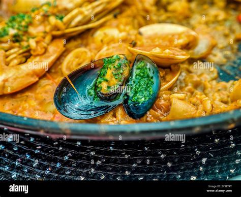 The traditional Spanish seafood dish called Paella in a black pan with ...