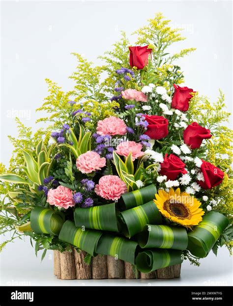 Big flower bouquet in wooden box with green leafs isolated on white ...