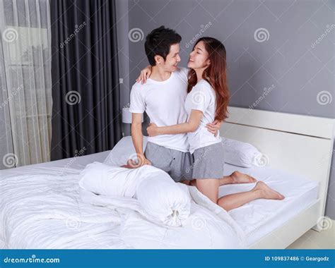 Happy Young Attractive Couple Hugging on Bed in Bedroom Stock Photo ...