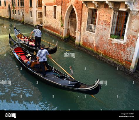 Two Gondolas navigating small Venice Canal Stock Photo - Alamy