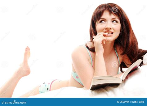 Woman reading in The Ritz-Carlton bed at a hotel