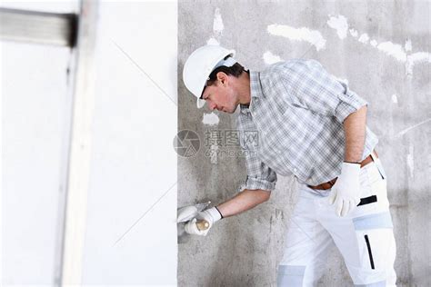 用抹子灰室内建筑工地墙壁的泥水匠人戴头高清图片下载-正版图片503040623-摄图网