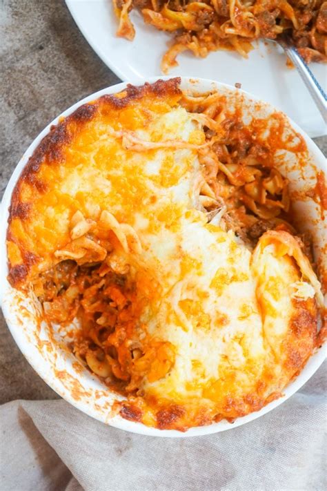 top-down view of a white 9x13 casserole dish of Grandmaâ��s ground beef casserole with a scoop out a