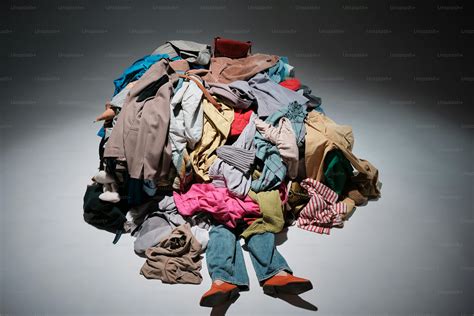 A pile of clothes sitting on top of a white floor photo – Consumerism ...