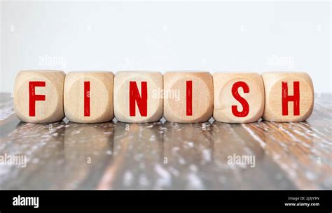 word finish of wooden letters on a red table and blue background Stock ...