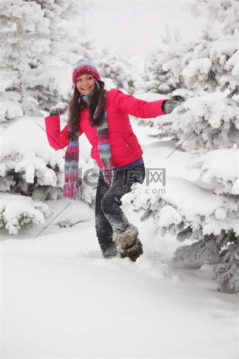 冬天的女人在雪地上玩雪球高清摄影大图-千库网