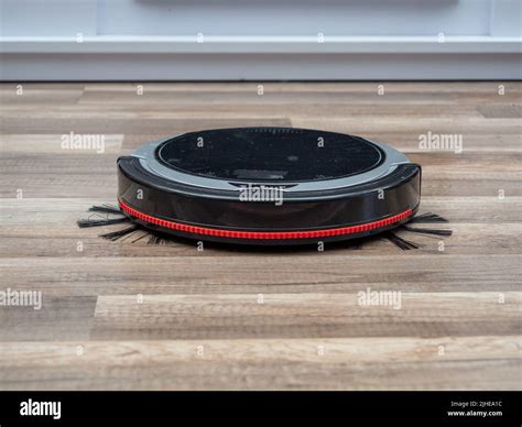 Robotic vacuum cleaner on a laminated wooden floor. Robot vacuum ...