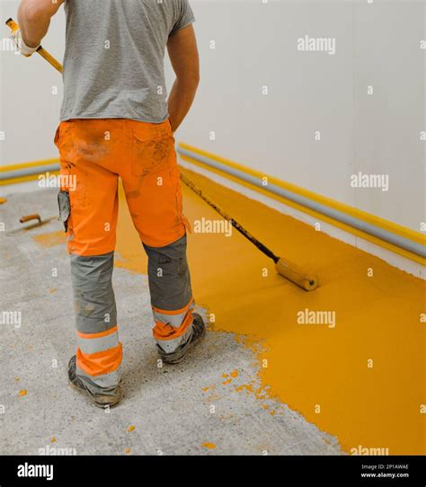 epoxy flooring applicator performs painting works with polyurethane ...