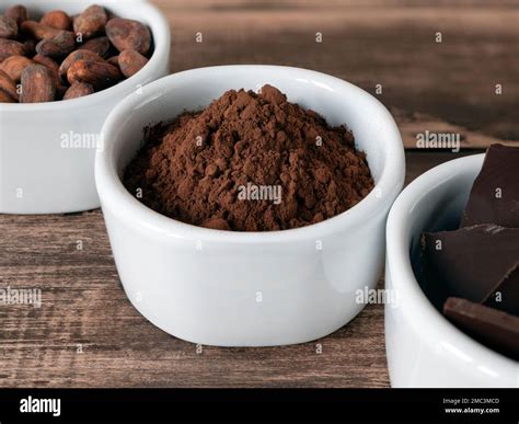 Cocoa powder in the bowl and other chocolate products on the wooden ...