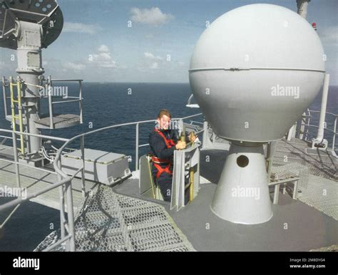 A crew member stands beside a radar dome aboard the nuclear-powered ...