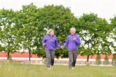Happy fit senior couple jogging in park | Premium Photo