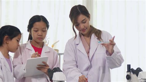 Asian schoolgirls are studying science and technology in a lab ...