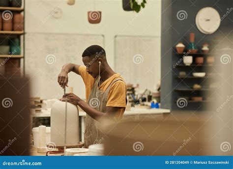 African Ceramist Making Holes in a Pot at a Bench in a Workshop Stock ...