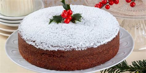 side view of Vaselopita - Greek New Years Cake dusted with powdered sugar with a slice cut out of it