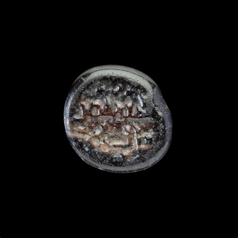 AN EARLY ISLAMIC GLASS WEIGHT OF QUARTER DIRHAM