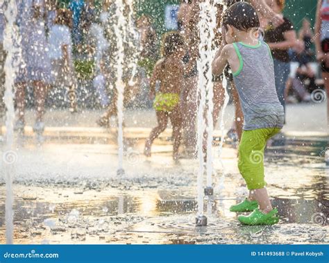 激动的男孩获得在水注之间的乐趣，在喷泉 夏天在城市 库存照片. 图片 包括有 孩子, 喷泉, 外面, 少许 - 141493688