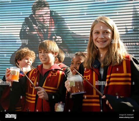 Kids dressed as Hogwarts students pose with non-alcoholic "butterbeer ...