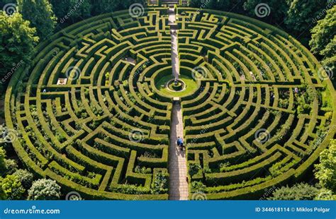An Aerial View of a Large, Circular Hedge Maze with Two People Walking ...