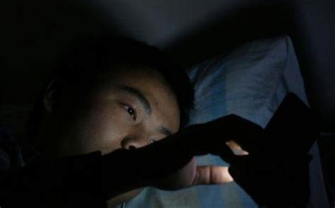 亚洲女性晚上睡觉前会在床上使用智能手机。手机成瘾的概念。照片摄影图片_ID:300001682-Veer图库