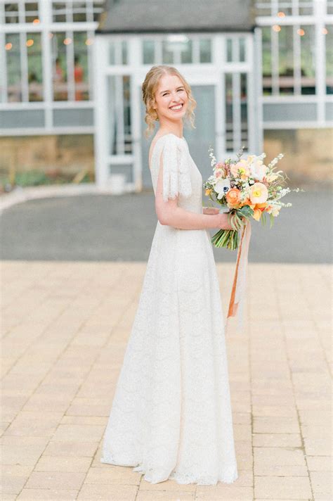 Carenza | Real bride in Dahlia lace & silk wedding gown: flutter sleeves, full skirt & deep V ...