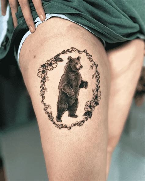 a bear tattoo on the side of a woman