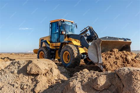 Bulldozer or loader moves the earth at the construction site against ...