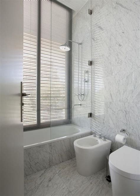 通铺的白色大理石瓷砖，让卫生间更显简约风范。一面圆形镜子还做了藏光的-家居美图_装一网装修效果图