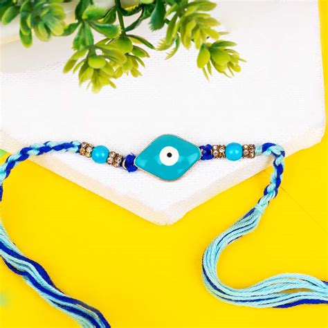 Send Designer Evil Eye Rakhi with Haldiram''s Badam Pista Cookie Online ...
