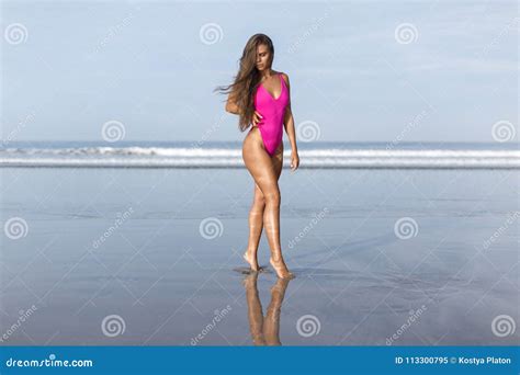 Beautiful Girl in a Pink Bathing Suit on the Blue Ocean at Dawn Stock ...