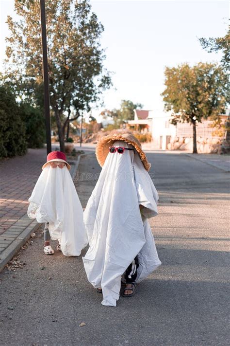Trendy Sheet Ghosts Costumes on Little Kids Standing on a Suburbs ...