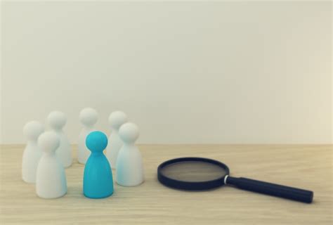 Magnifying glass with blue people model outstanding out from the crowd ...