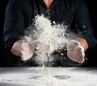 黑衣厨师将白面粉洒在不同方向产品散布灰尘黑色背景坐在一张桌子上的男人高清图片下载-正版图片307107744-摄图网
