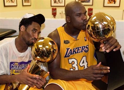 Kobe Bryant kisses the NBA championship trophy as Shaquille O'Neal ...