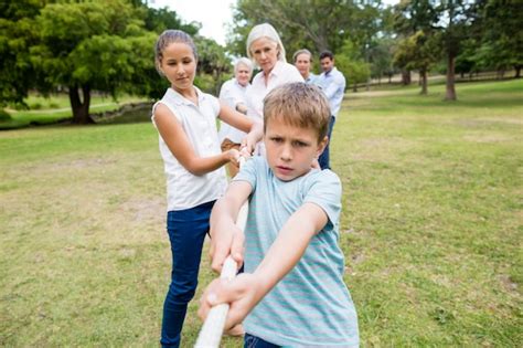 Multi-generation family pulling a rope in tug of war | Premium Photo