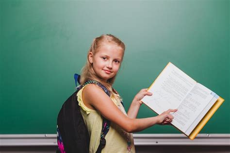 Pupil girl pointing at book | Free Photo