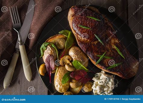 Beef Steak and Side Dish of Baked Potatoes and Mushrooms Stock Photo ...