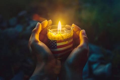 Hands holding a candle wrapped in the american flag symbolizing ...