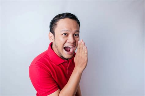 Young attractive man wearing a red tshirt shouting and screaming loud ...