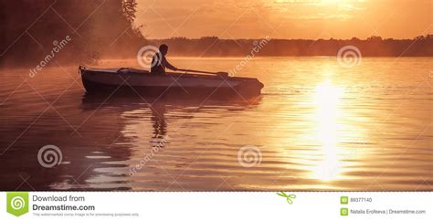 在金黄日落期间，一个年轻人在湖乘坐小船 剪影，日落的划船者的图象 荡桨在背后照明的人一条小船 库存照片 - 图片 包括有 夜间, 捕鱼 ...