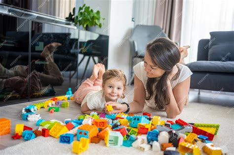 Premium Photo | Little girl play with constructor toy on floor in home ...