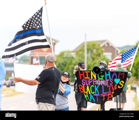 Black Lives Matters protestors holding signs and yelling on a megaphone ...