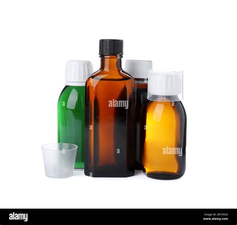 Bottles of syrups with measuring cups on white background. Cough and ...