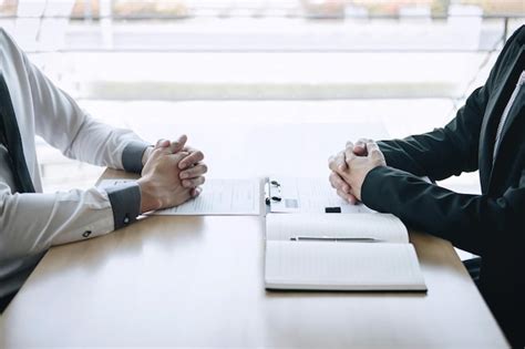 候補者の面接をテーブルの上で取っているマネージャーのミッドセクション | Premium写真