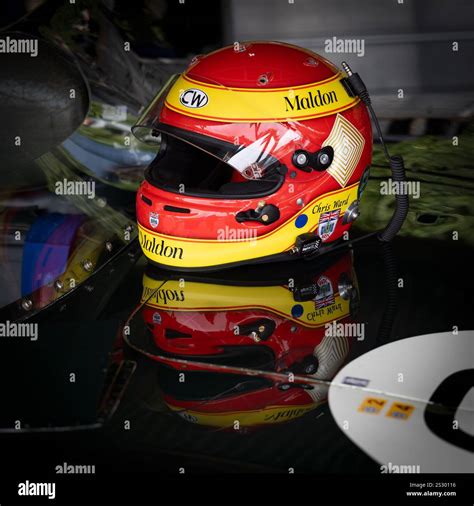 Chris Ward's red and yellow racing crash helmet with reflection in the bonnet of the Jaguar D ...