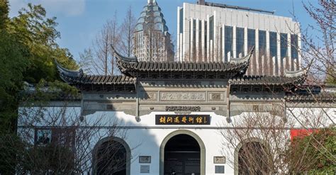 Photo of an elaborate Chinese temple with hedges in front.